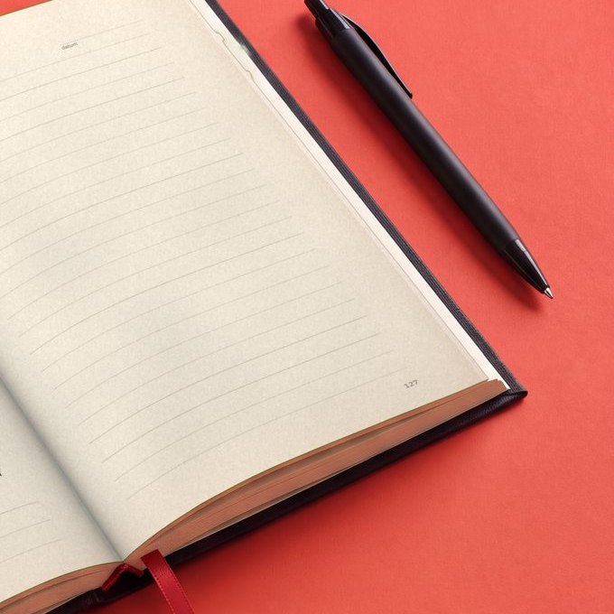 De journal ligt open op een lege bladzijde, met een pen ernaast