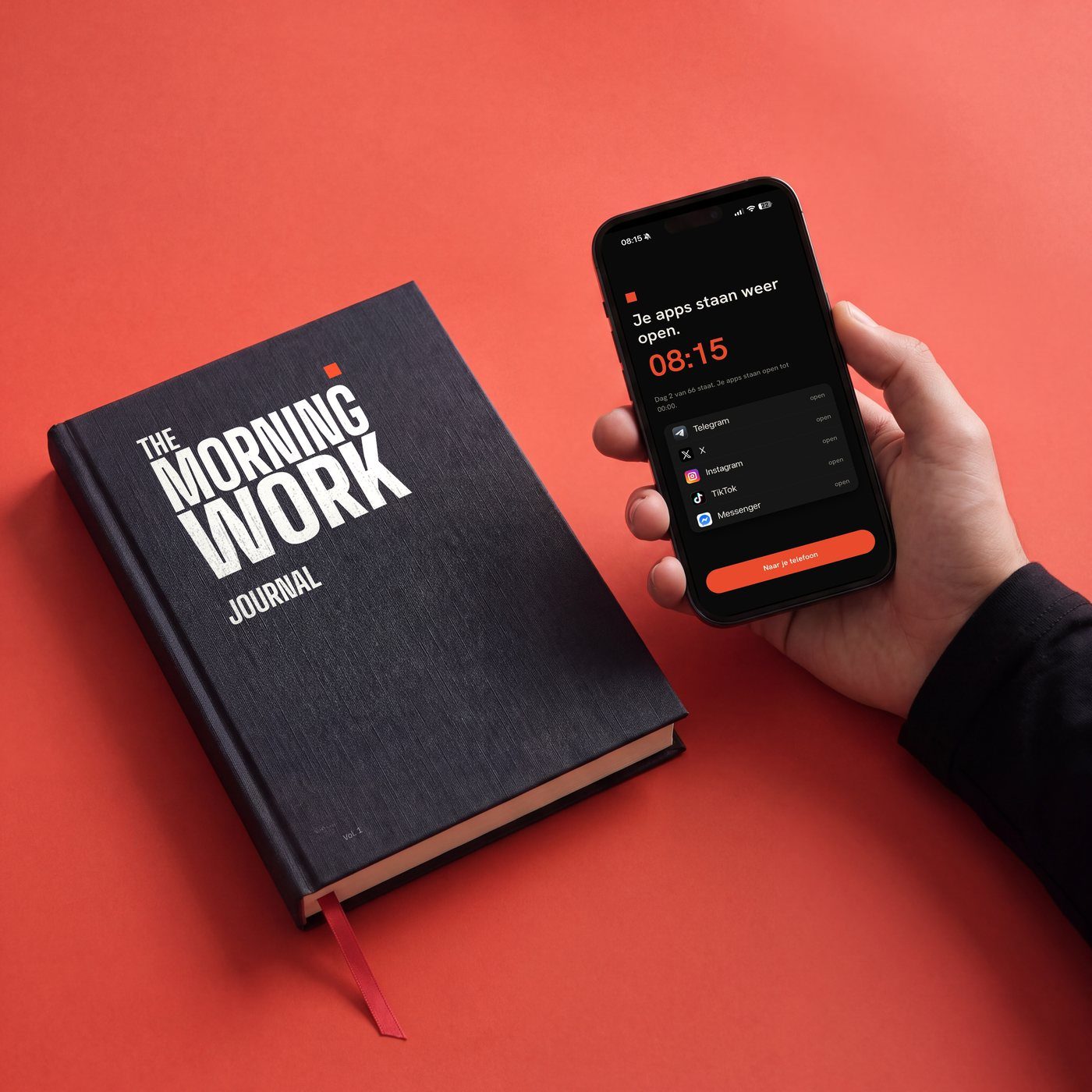 De telefoon in een hand naast de journal, het scherm zegt Je apps staan weer open, 08:15